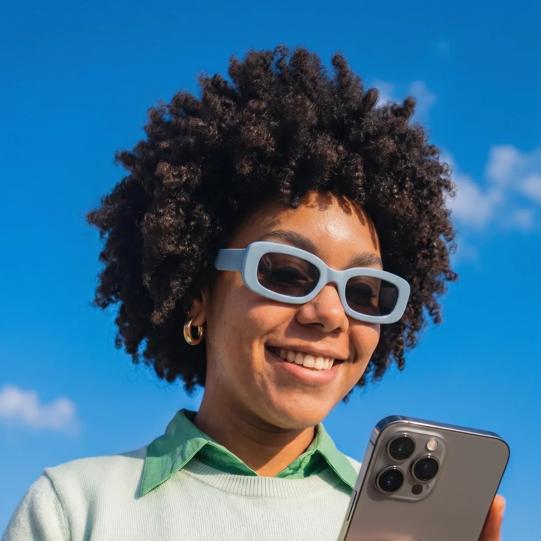 A happy Get Approved customer checking her phone in the sun.